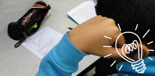 Un jeune qui fait ses devoirs avec un dessin d'ampoule